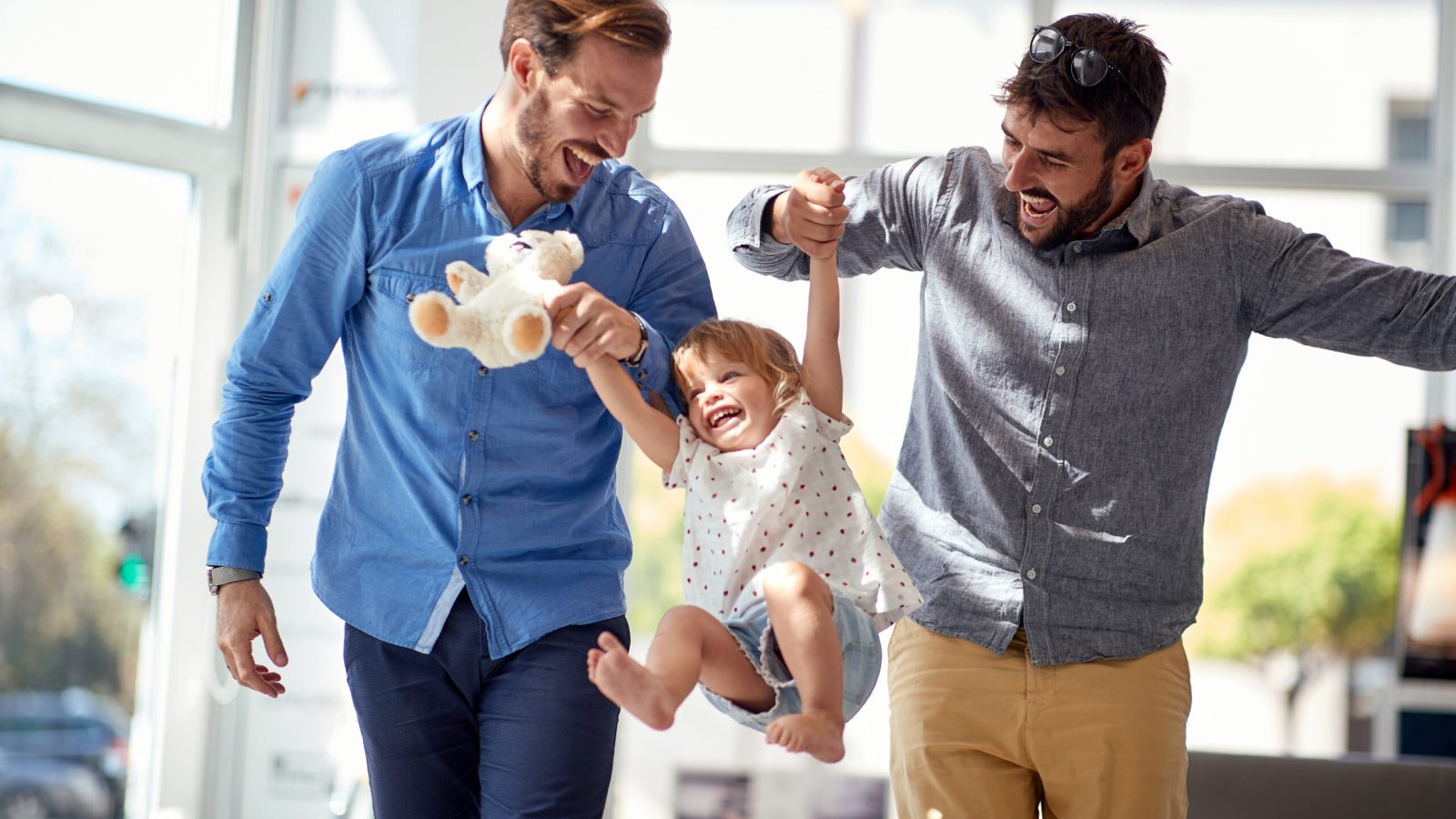 Happy Child girl at shopping  with gay parents.family having fun at shopping.