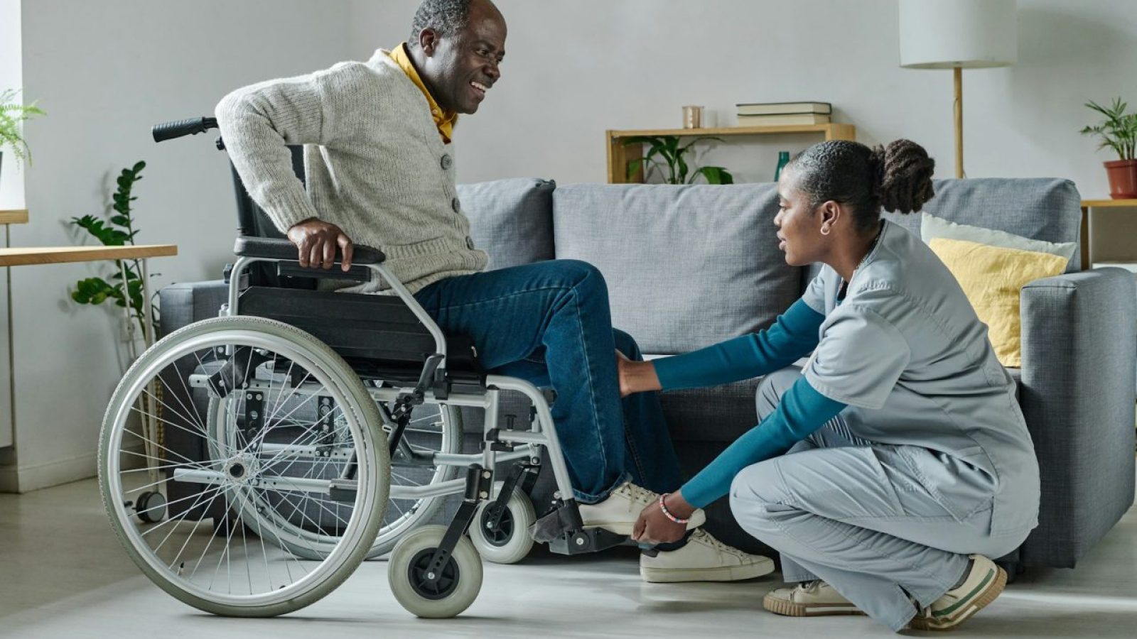 caregiver-helping-man-to-sit-on-wheelchair.jpg